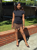 Person standing on a sidewalk with a grassy area and brick path in the background