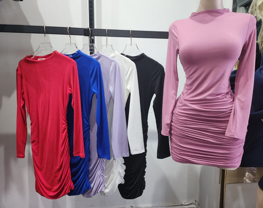 Mannequin wearing a pink dress with other dresses on hangers in the background.